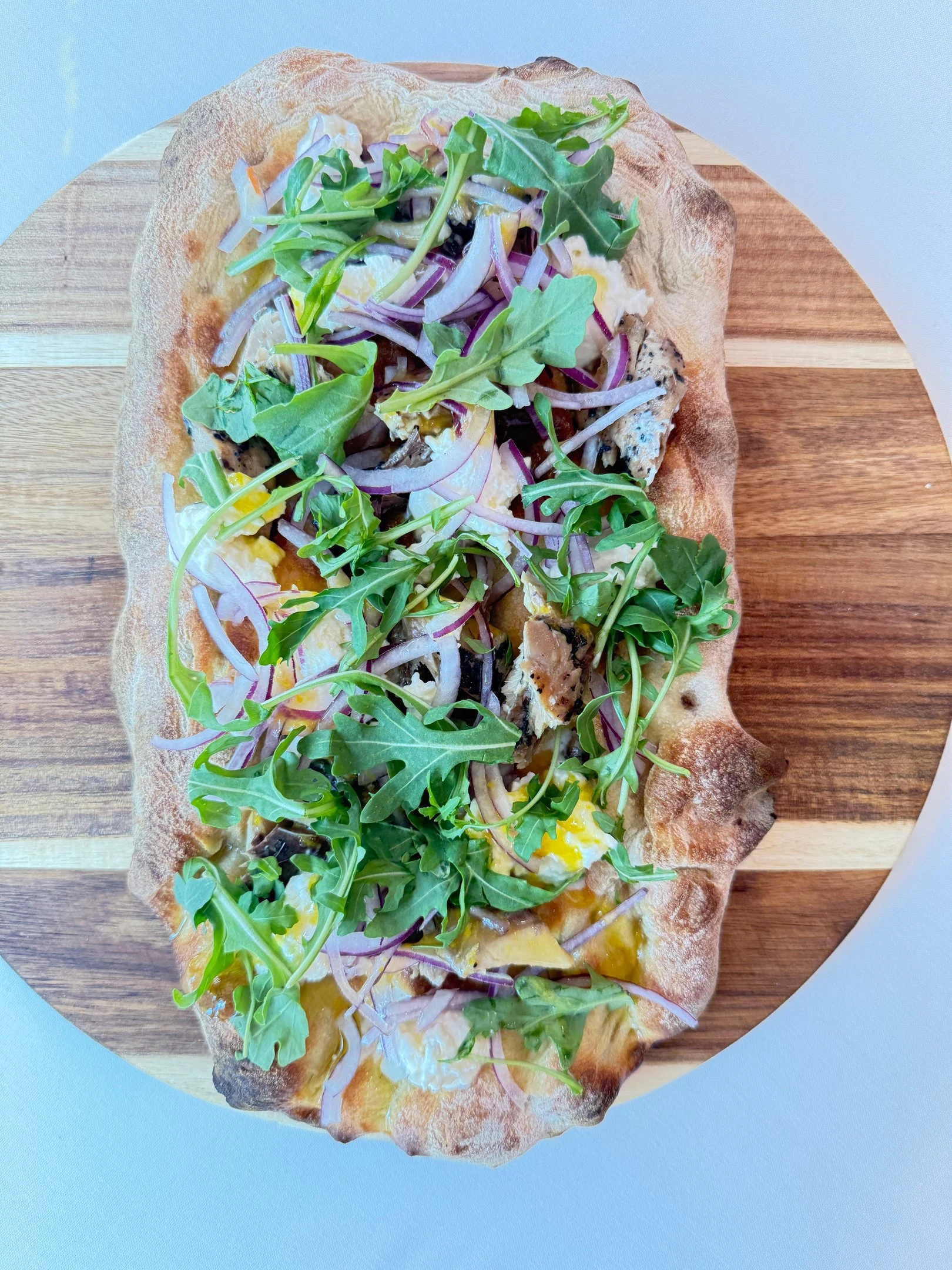 Davanti pinsa topped with arugula and red onion