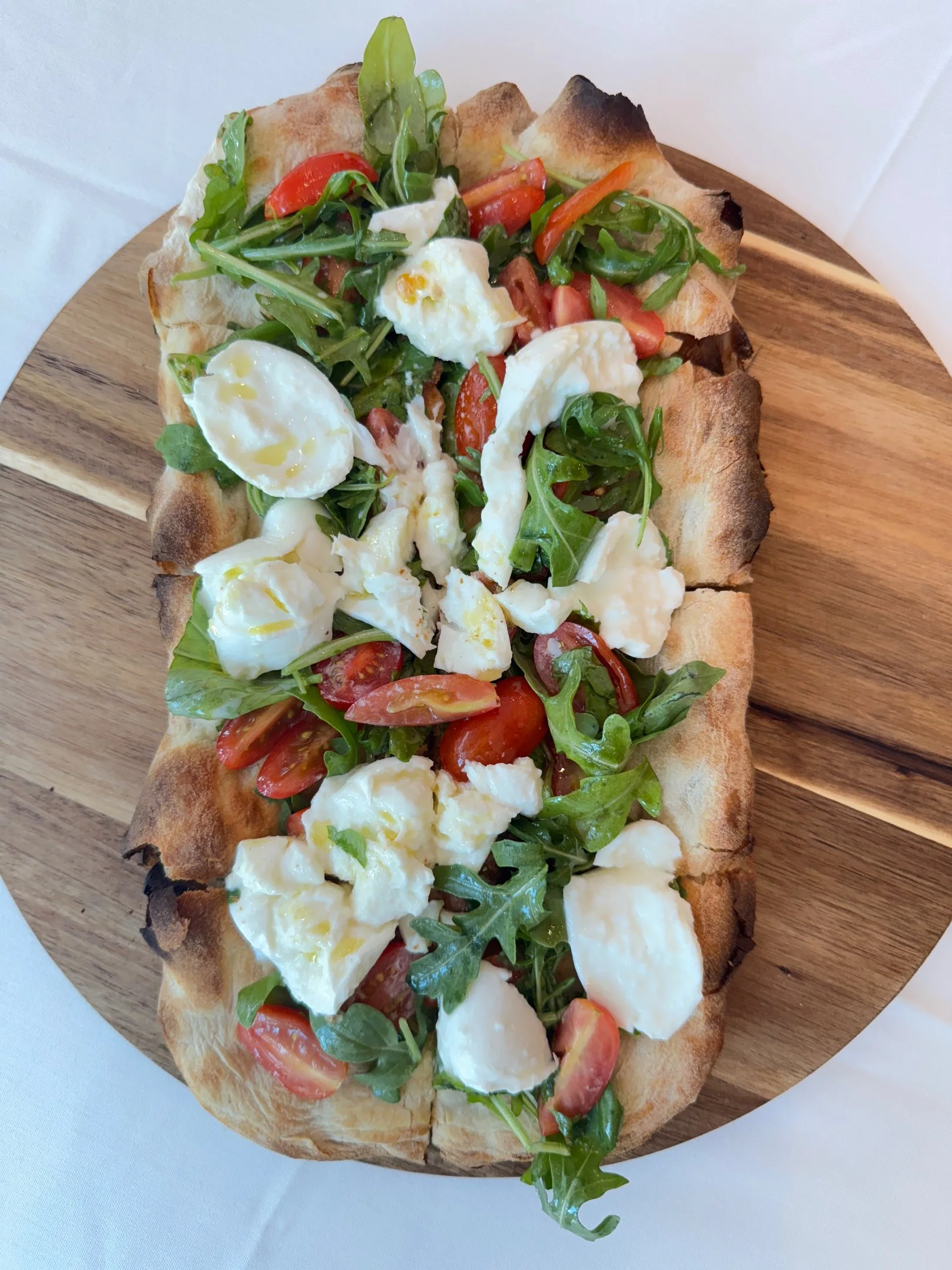 Roman-style pinsa topped with burrata and tomatoes